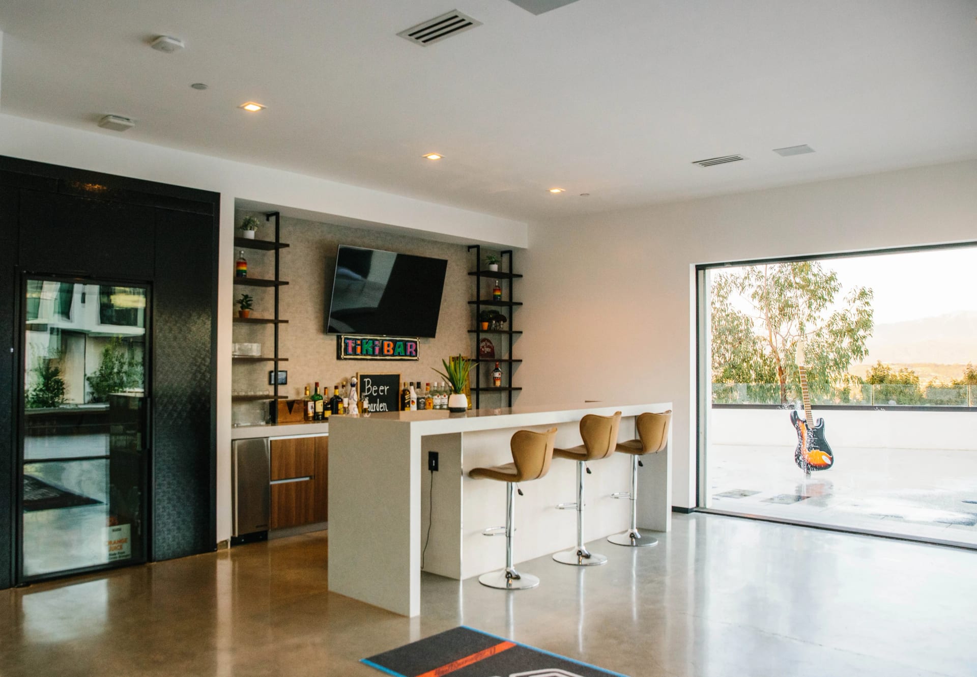 A bright kitchen with warm wood cabinetry, a central island, and garden views
