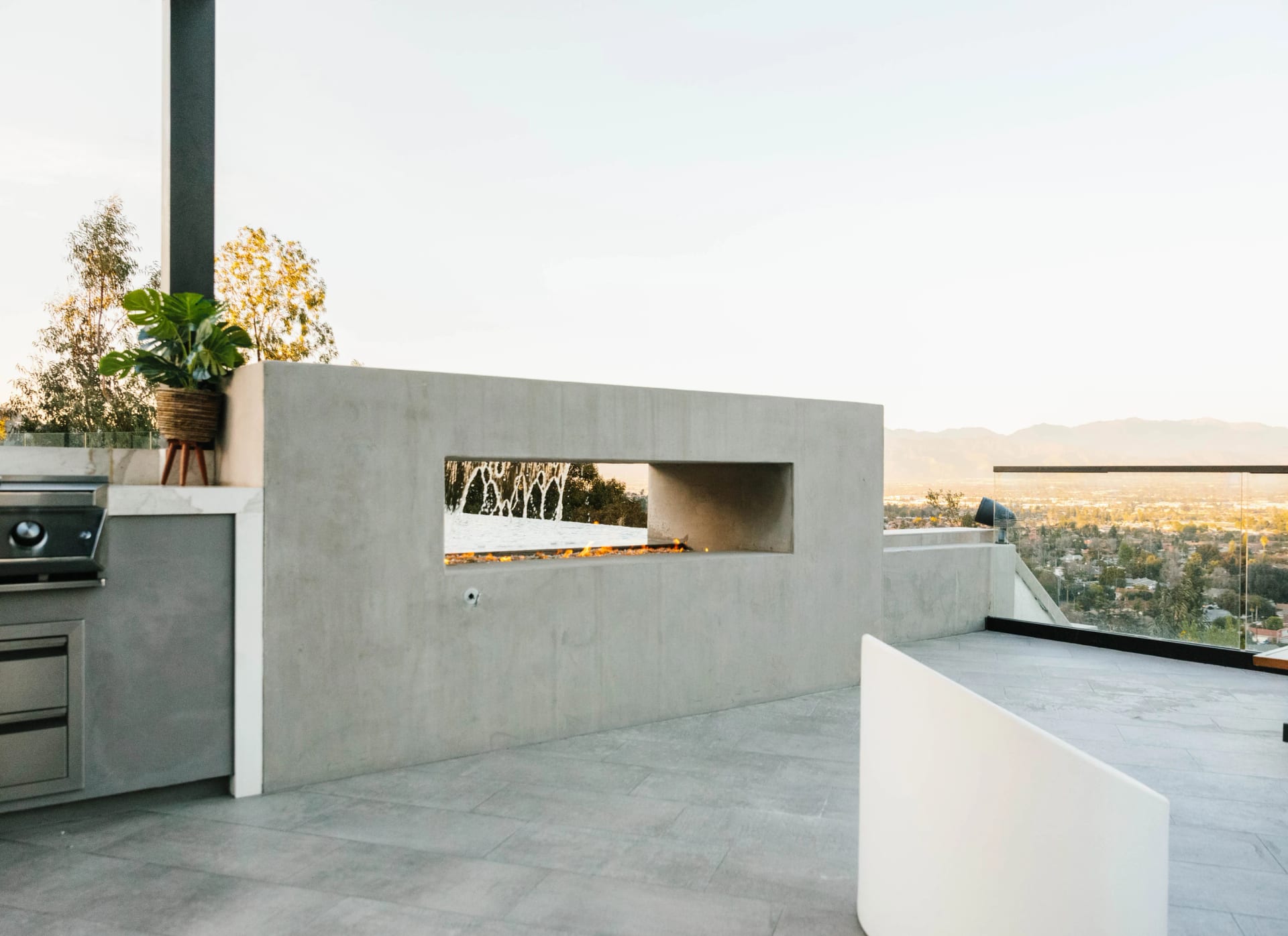 Outdoor kitchen with a see-through fireplace on a hilltop terrace