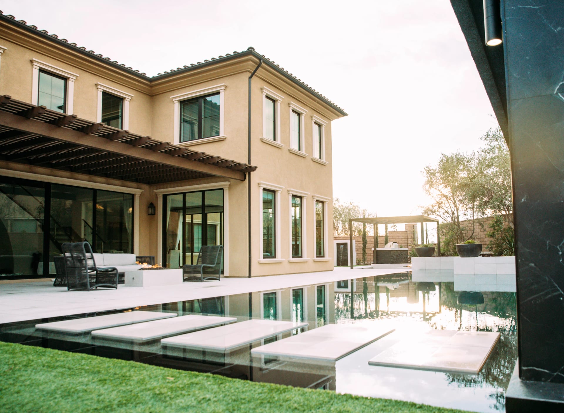 A Mediterranean style home opening onto a geometric pool and landscaped garden