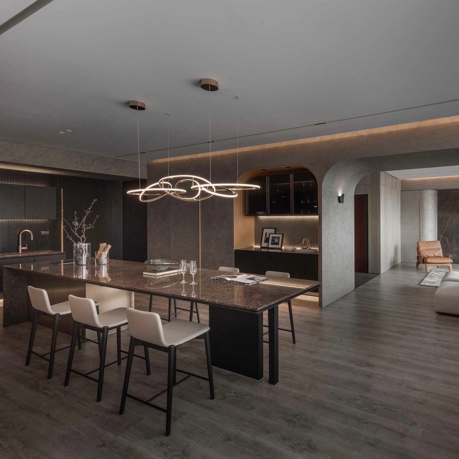 Open plan kitchen with a long island, bar seating and a sculptural light