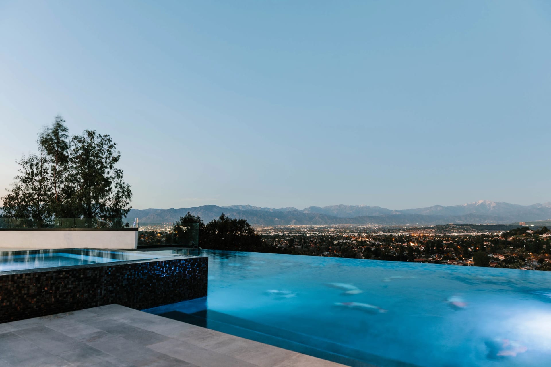 A blue infinity pool with a wide view across the California landscape