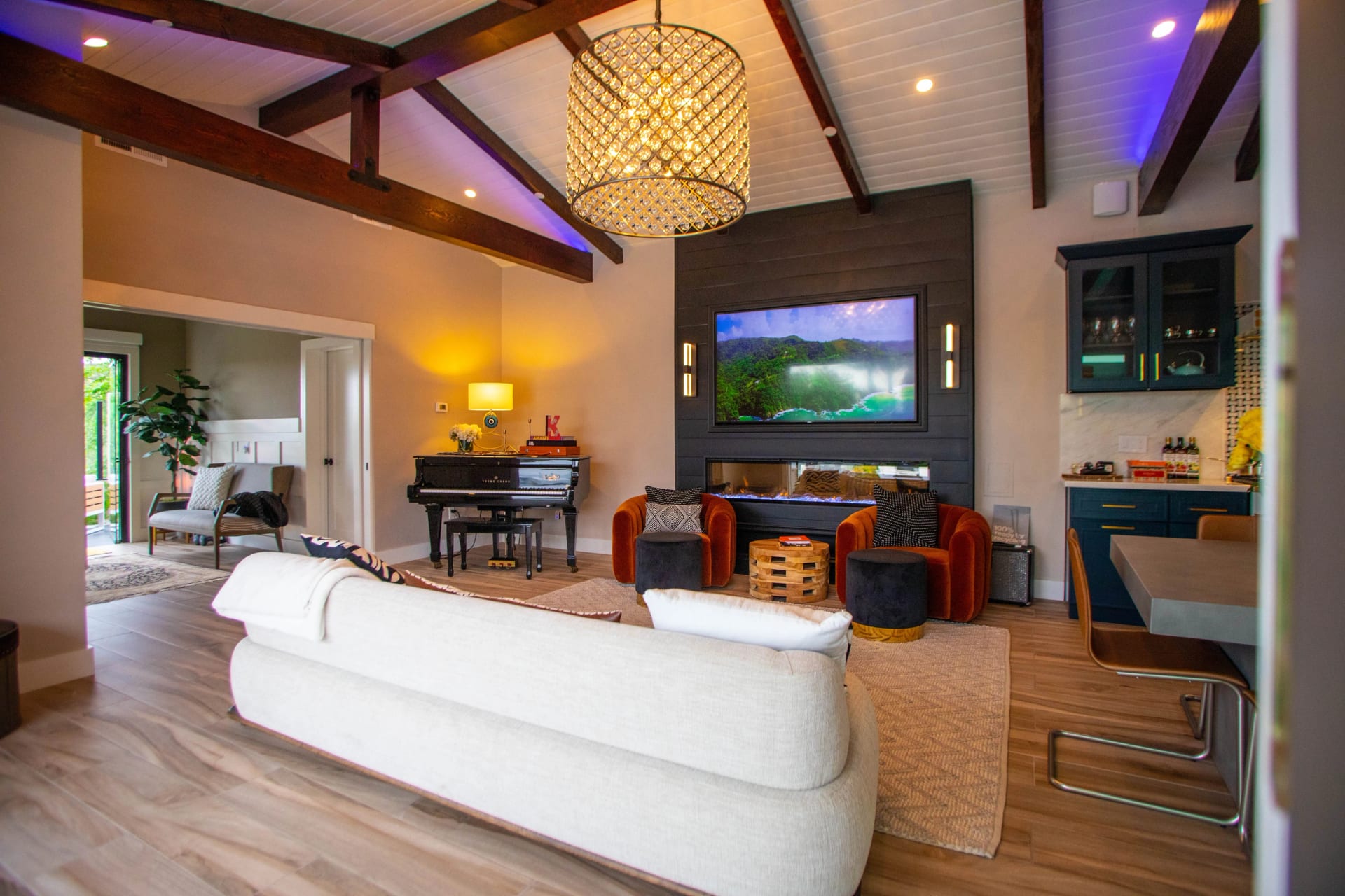 A generous living room with exposed timber beams and a stone fireplace